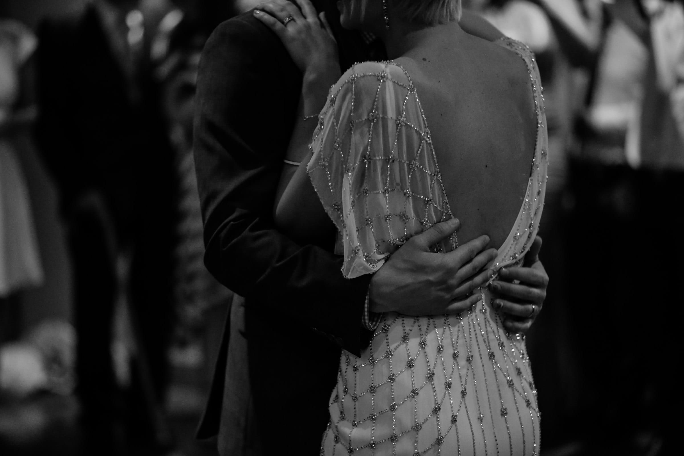 Un couple en tenue de soirée enlacé, en noir et blanc